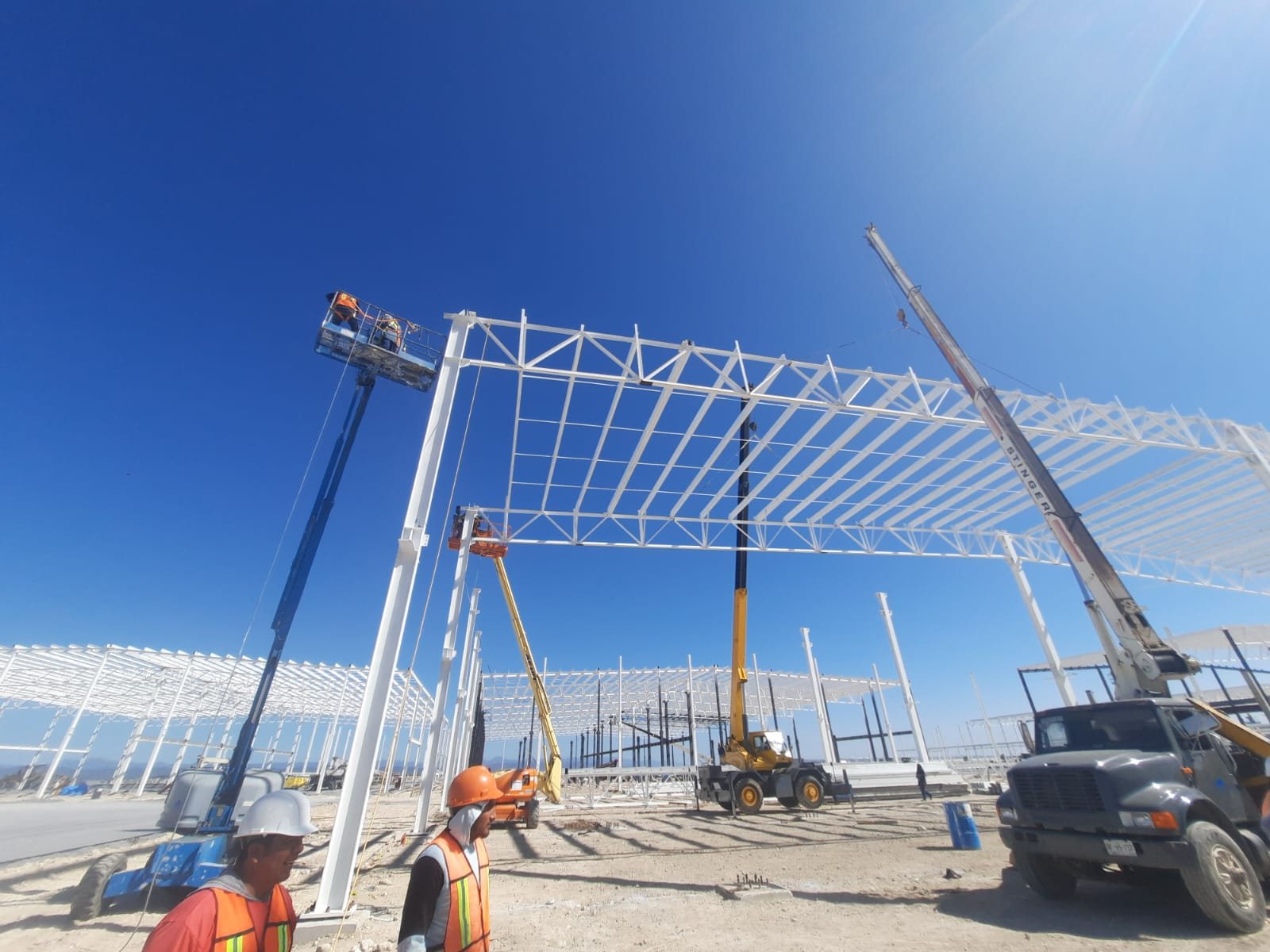 Equipos de elevación trabajando sobre una estructura de gran escala.